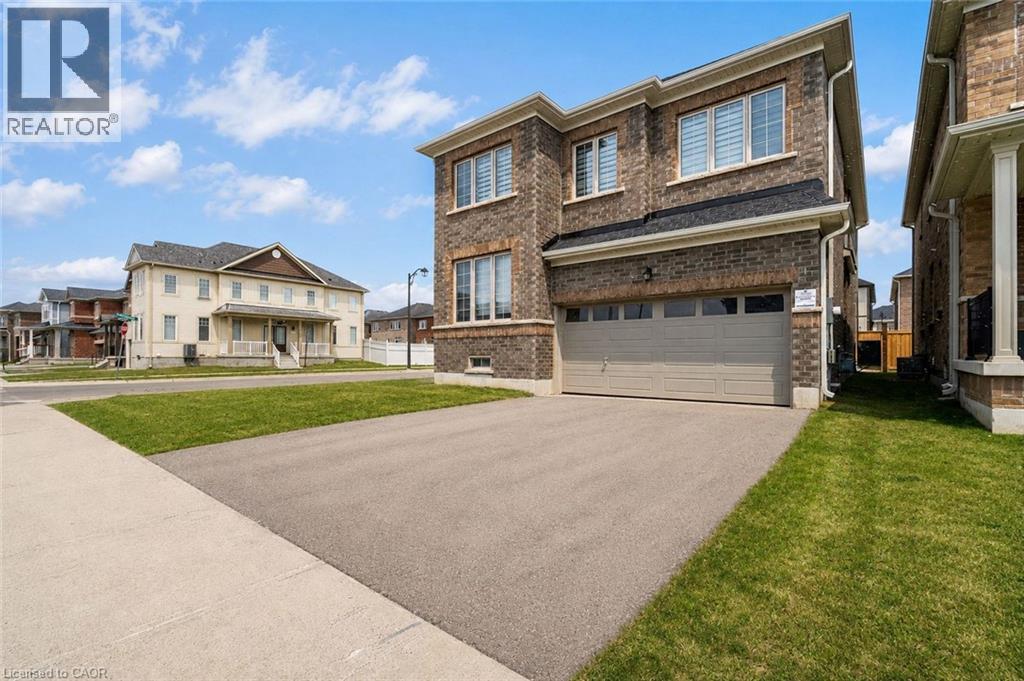Brick exterior with a two-car garage, asphalt driveway, and concrete sidewalk - 525 Red Elm Road, Shelburne, ON - Outdoor With Facade