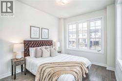 Hardwood-finish flooring, white painted walls, multi-pane window, flush mount ceiling light -