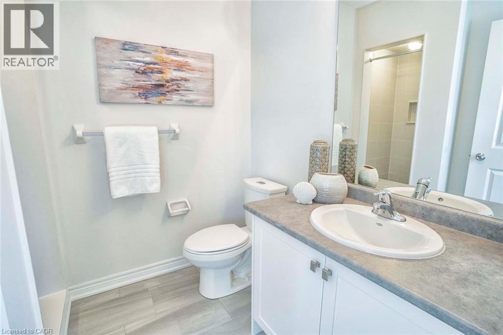 White vanity with cabinet storage, integrated sink, and gray countertop - 525 Red Elm Road, Shelburne, ON - Indoor Photo Showing Bathroom