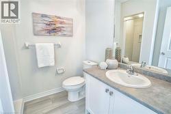 White vanity with cabinet storage, integrated sink, and gray countertop -