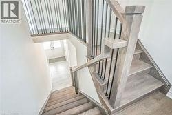 Hardwood staircase with contemporary black metal balusters, wood-finish flooring, and a double-door entryway -