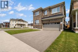 Brick exterior with a two-car garage, asphalt driveway, and concrete sidewalk -