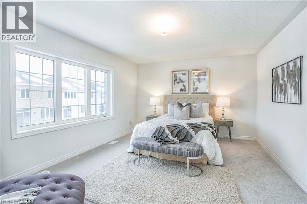 Bright room featuring a large window, neutral carpeting, and a ceiling-mounted light fixture - 525 Red Elm Road, Shelburne, ON - Indoor Photo Showing Bedroom