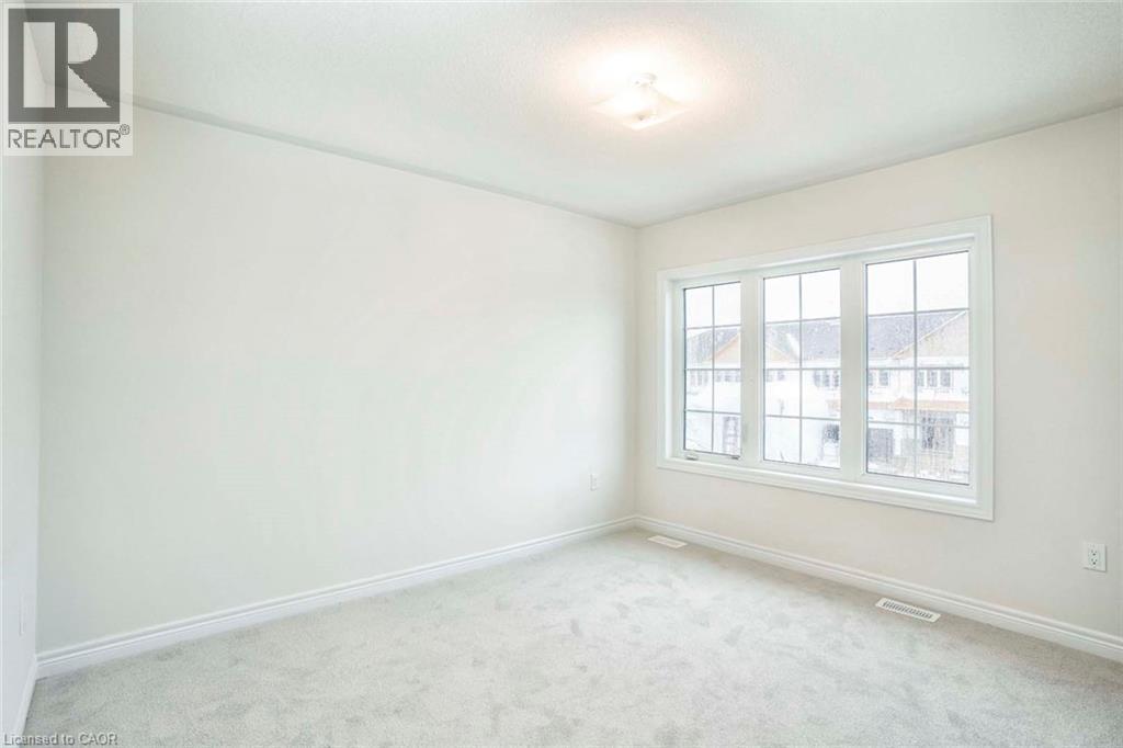 Neutral wall finishes, plush carpet flooring, recessed lighting, and a multi-pane window - 525 Red Elm Road, Shelburne, ON - Indoor Photo Showing Other Room