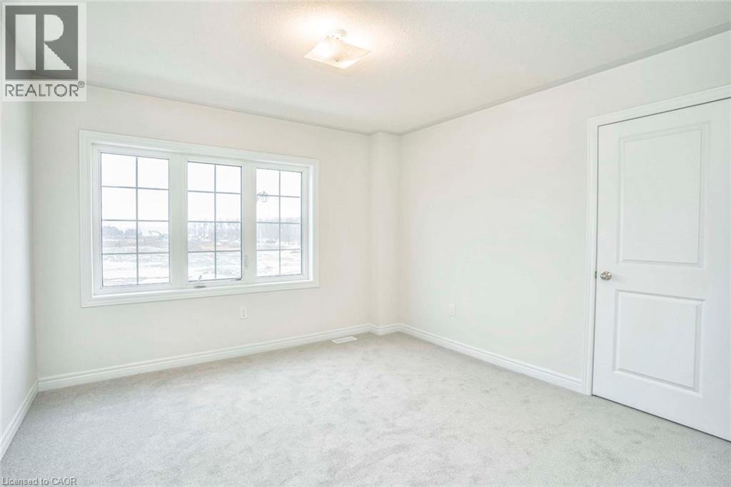 Carpeted flooring, white walls, double panel interior door, window with grid pattern, and flush-mount ceiling light fixture - 525 Red Elm Road, Shelburne, ON - Indoor Photo Showing Other Room