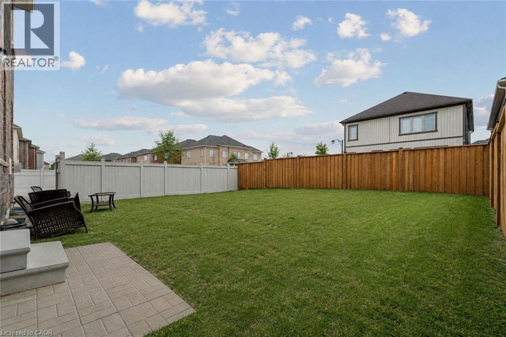 Expansive green lawn with a paver patio and a mix of wood and vinyl fencing - 525 Red Elm Road, Shelburne, ON - Outdoor