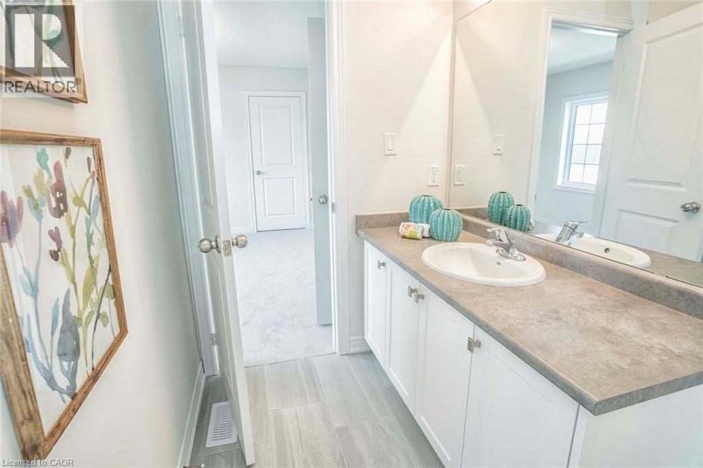 Vanity with a white undermount sink, dual-handle faucet, and white cabinetry with silver-tone hardware - 525 Red Elm Road, Shelburne, ON - Indoor Photo Showing Bathroom