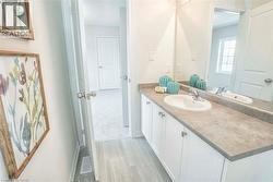 Vanity with a white undermount sink, dual-handle faucet, and white cabinetry with silver-tone hardware -