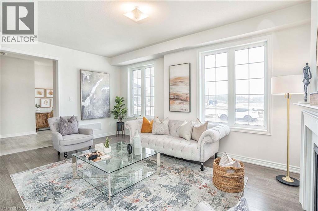 Bright living space featuring wood-finish flooring, white walls, and a recessed ceiling light fixture - 525 Red Elm Road, Shelburne, ON - Indoor Photo Showing Living Room With Fireplace