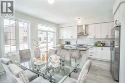 Open-concept kitchen with white shaker cabinetry, stainless steel appliances, and a central island with bar seating -