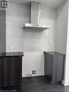 Stainless steel range hood with a light-toned tile backsplash - 