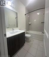 Bathroom featuring a vanity with dark wood-finish cabinetry, white countertop, and an undermount sink - 