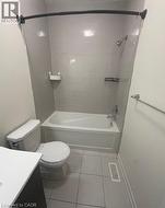 Bathroom featuring a white bathtub, toilet, and a vanity with a white countertop - 