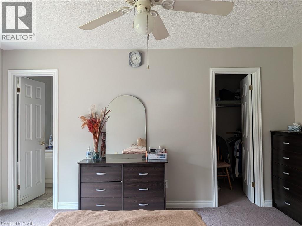 Neutral wall paint, ceiling fan light fixture, arched mirror, recessed closet, and paneled interior doors - 45 Caswell Drive Unit# Upper, Hamilton, ON - Indoor Photo Showing Bedroom