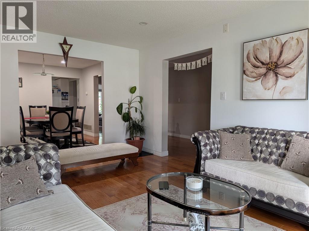Hardwood flooring throughout, leading to an arched entryway - 45 Caswell Drive Unit# Upper, Hamilton, ON - Indoor Photo Showing Living Room