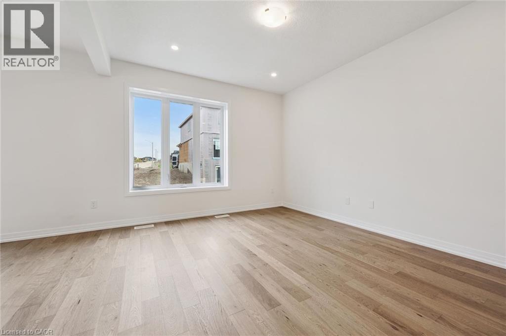 Hardwood flooring, recessed lighting, large window with white trim, white walls, and a ceiling light fixture - 451 Benninger Street, Kitchener, ON