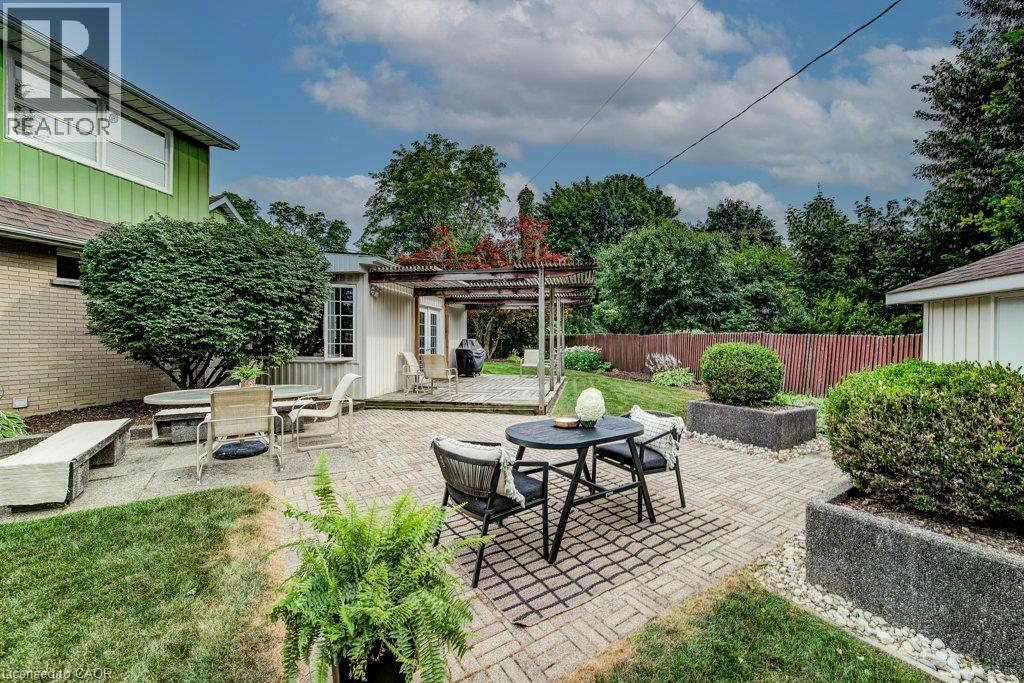 Expansive backyard featuring a brick paver patio, a concrete patio, and a pergola-covered deck - 97 Somerset Crescent, Waterloo, ON - Outdoor