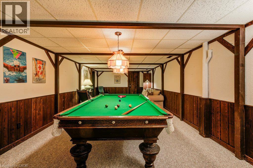 Recreation room featuring a paneled wood accent wall, exposed wood beams, and a drop ceiling with recessed lighting - 97 Somerset Crescent, Waterloo, ON - Indoor Photo Showing Other Room