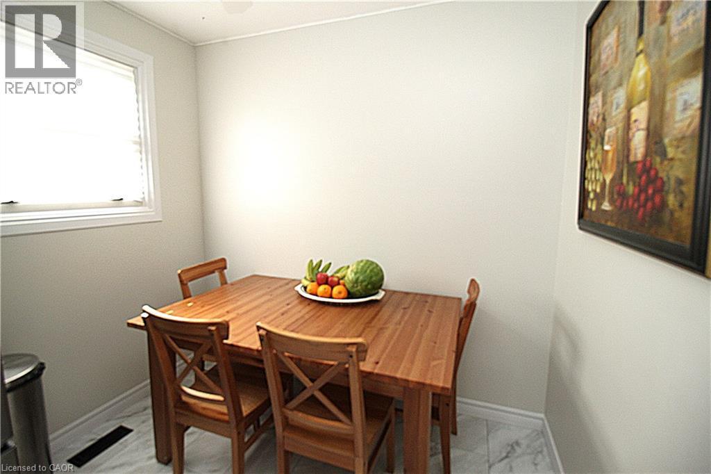 White-framed window with blinds, light-colored walls, white baseboards, and patterned floor tile - 35 Garden Crescent, Hamilton, ON - Indoor Photo Showing Dining Room