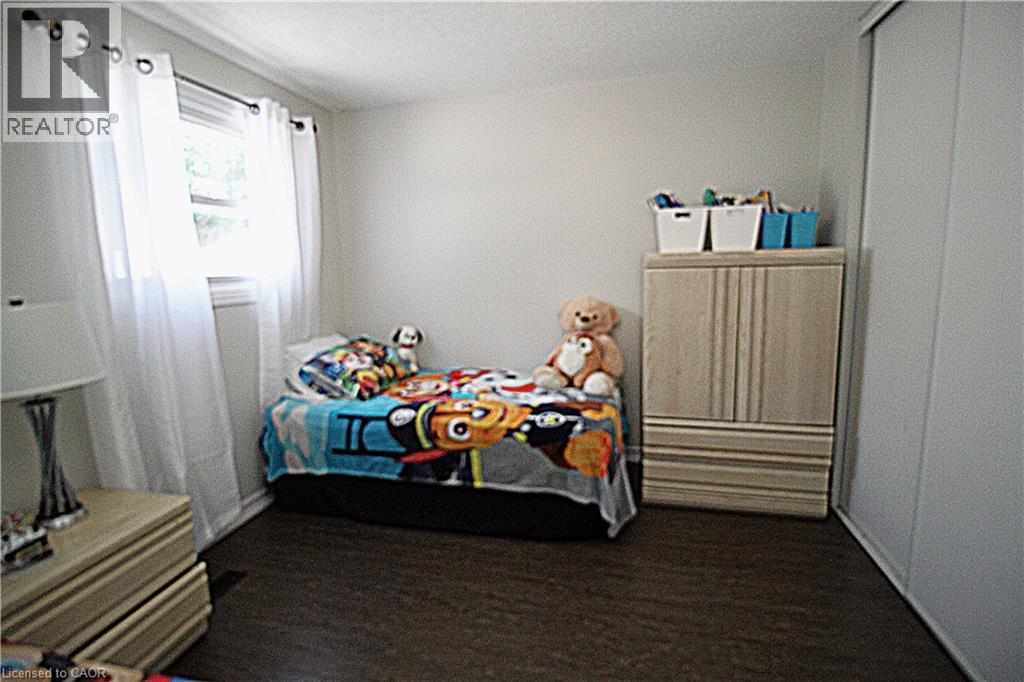 Wood-finish flooring with a white wall finish and a built-in sliding closet - 35 Garden Crescent, Hamilton, ON - Indoor Photo Showing Bedroom