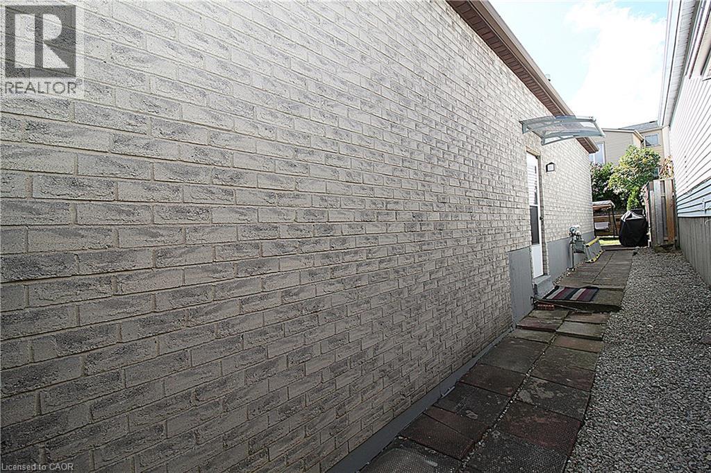 Light-colored brick exterior with a protective awning over the entry - 35 Garden Crescent, Hamilton, ON - Outdoor