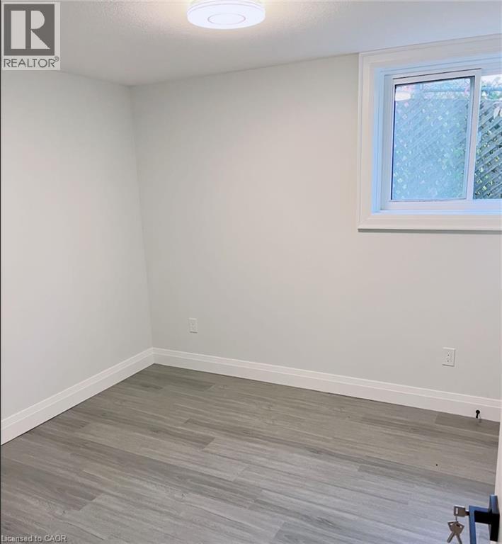 Neutral tone walls with white trim, wood-finish flooring, and a single window - 81 Second Avenue Unit# B, Kitchener, ON - Indoor Photo Showing Other Room