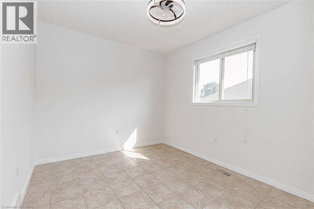 Recessed window with blinds, white walls, ceiling-mounted light fixture, and tiled flooring - 47 Queensway Drive, Strathroy, ON - Indoor Photo Showing Other Room