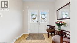 Double entry doors with decorative glass panels, light-toned wall paint, and tiled flooring -