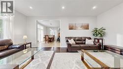 Bright living area featuring recessed lighting, dark wood-finish flooring, and ample natural light from large windows -