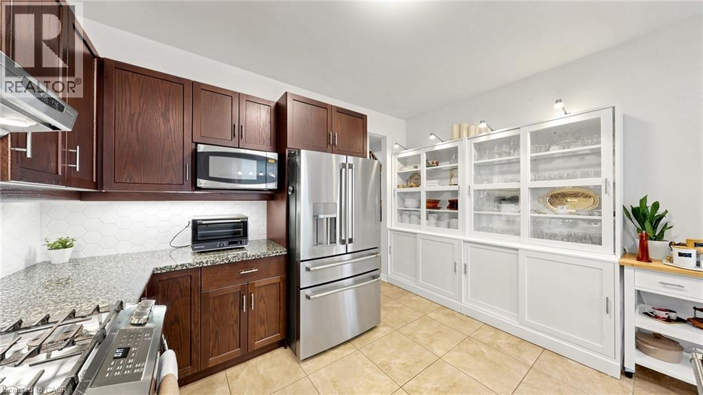 Wood-finish cabinetry paired with stainless steel appliances - 173 Raymond Road, Ancaster, ON - Indoor Photo Showing Kitchen