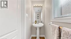 Pedestal sink with chrome faucet, wall-mounted mirror, and vanity light fixture -
