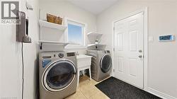 Laundry area featuring tiled flooring, a utility sink, and a window with blinds -