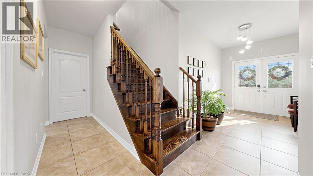 Foyer featuring tile flooring, wooden staircase with balusters, and double entry doors with decorative glass - 173 Raymond Road, Ancaster, ON - Indoor Photo Showing Other Room