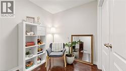 Rich wood-finish flooring, white paneled doors with bronze hardware, and a white cube storage unit -