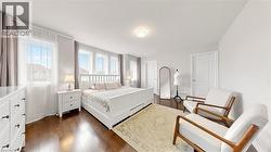 Bright room featuring multiple windows, dark wood-finish flooring, and white walls -