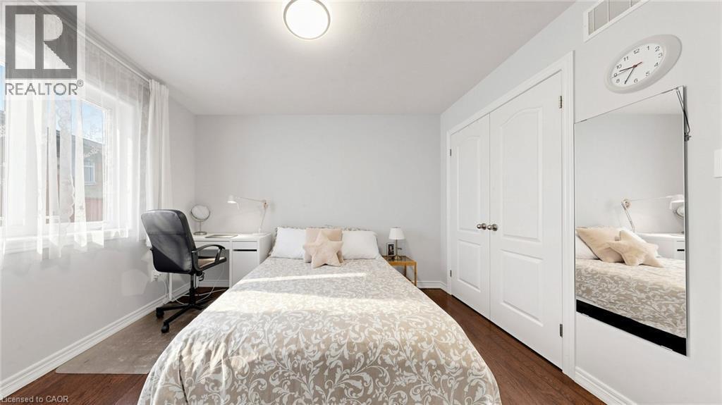 Expansive window, wood-finish flooring, white paneled doors, and a flush mount ceiling light - 173 Raymond Road, Ancaster, ON - Indoor Photo Showing Bedroom
