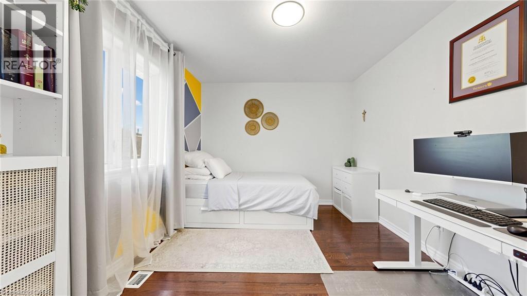 Hardwood flooring, white walls, built-in shelving, large window, and overhead lighting - 173 Raymond Road, Ancaster, ON - Indoor Photo Showing Bedroom