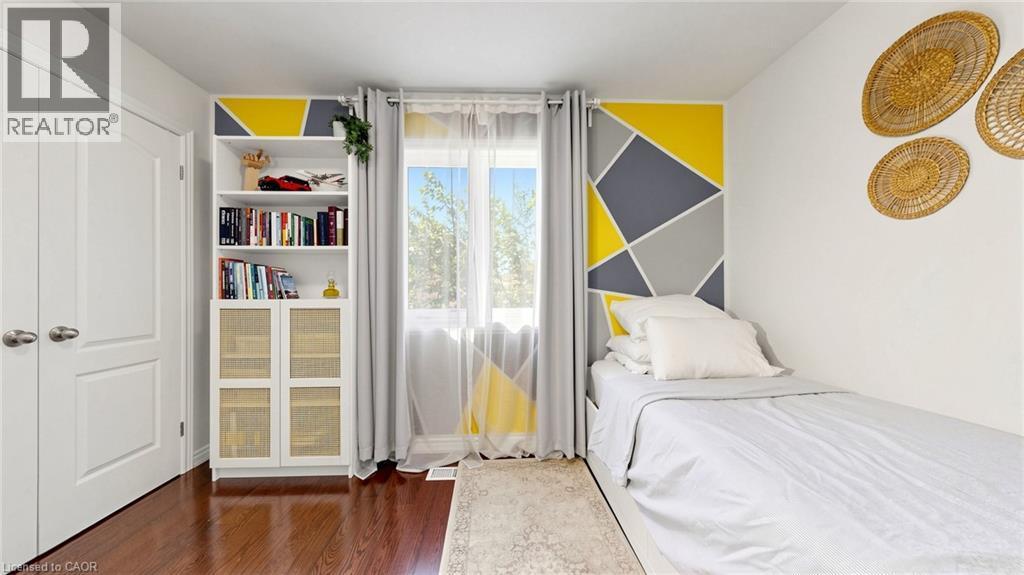 Wood-finish flooring, built-in shelving with lower cabinet storage, and a large window with natural light - 173 Raymond Road, Ancaster, ON - Indoor