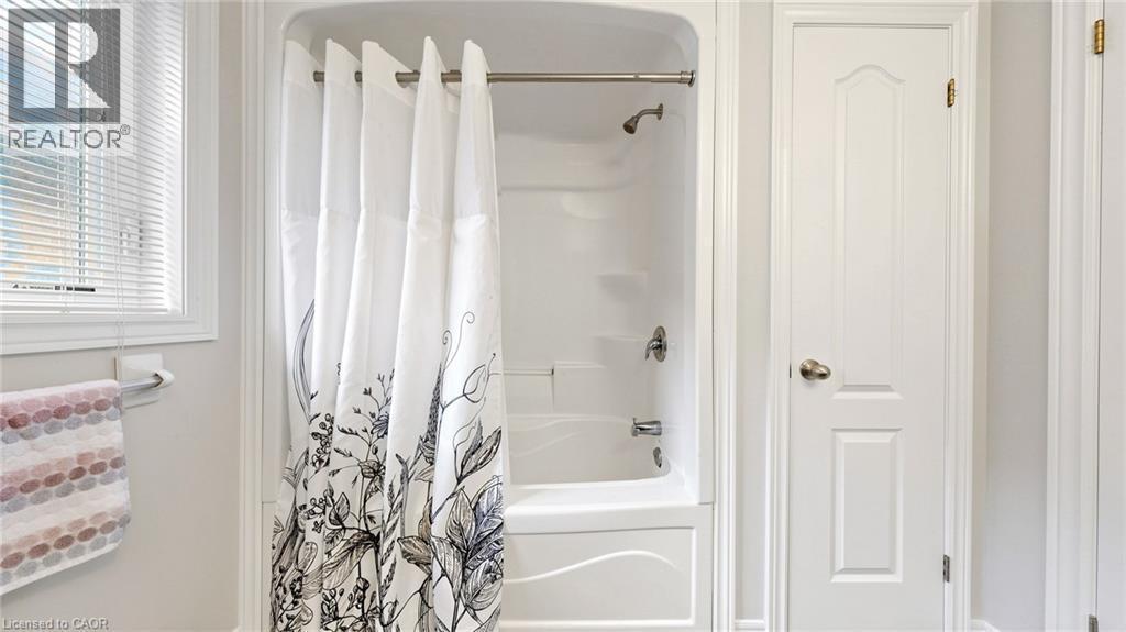White bath-shower combination with a chrome shower head and faucet - 173 Raymond Road, Ancaster, ON - Indoor Photo Showing Bathroom