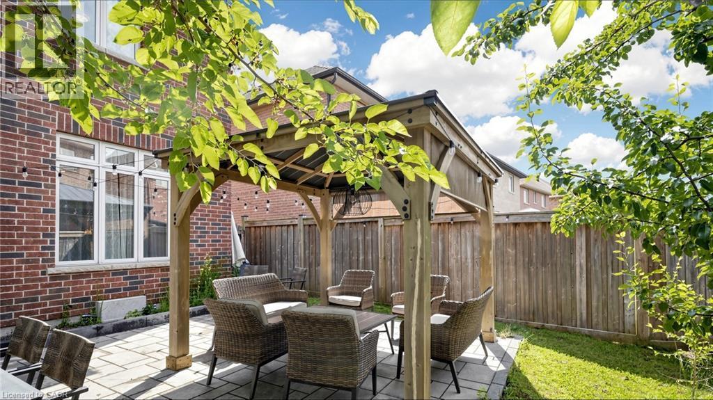 Patio area featuring a wood pergola, string lighting, and a paved surface - 173 Raymond Road, Ancaster, ON - Outdoor With Deck Patio Veranda