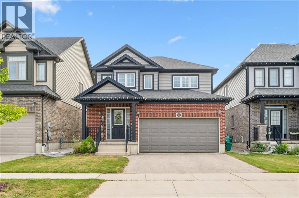 Brick and siding exterior, concrete driveway, attached two-car garage, covered porch entry, and mature landscaping - 360 Freure Drive, Cambridge, ON - Outdoor With Facade