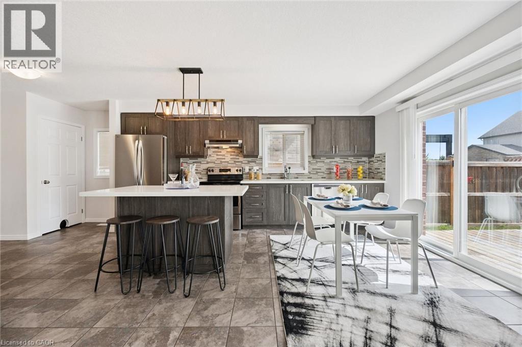 Kitchen with wood-finish cabinetry, stainless steel appliances, and an island featuring a white countertop - 360 Freure Drive, Cambridge, ON - Indoor