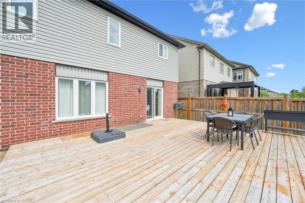 Expansive rear deck, brick exterior, sliding glass door access, white frame windows, and privacy fencing - 360 Freure Drive, Cambridge, ON - Outdoor With Deck Patio Veranda With Exterior