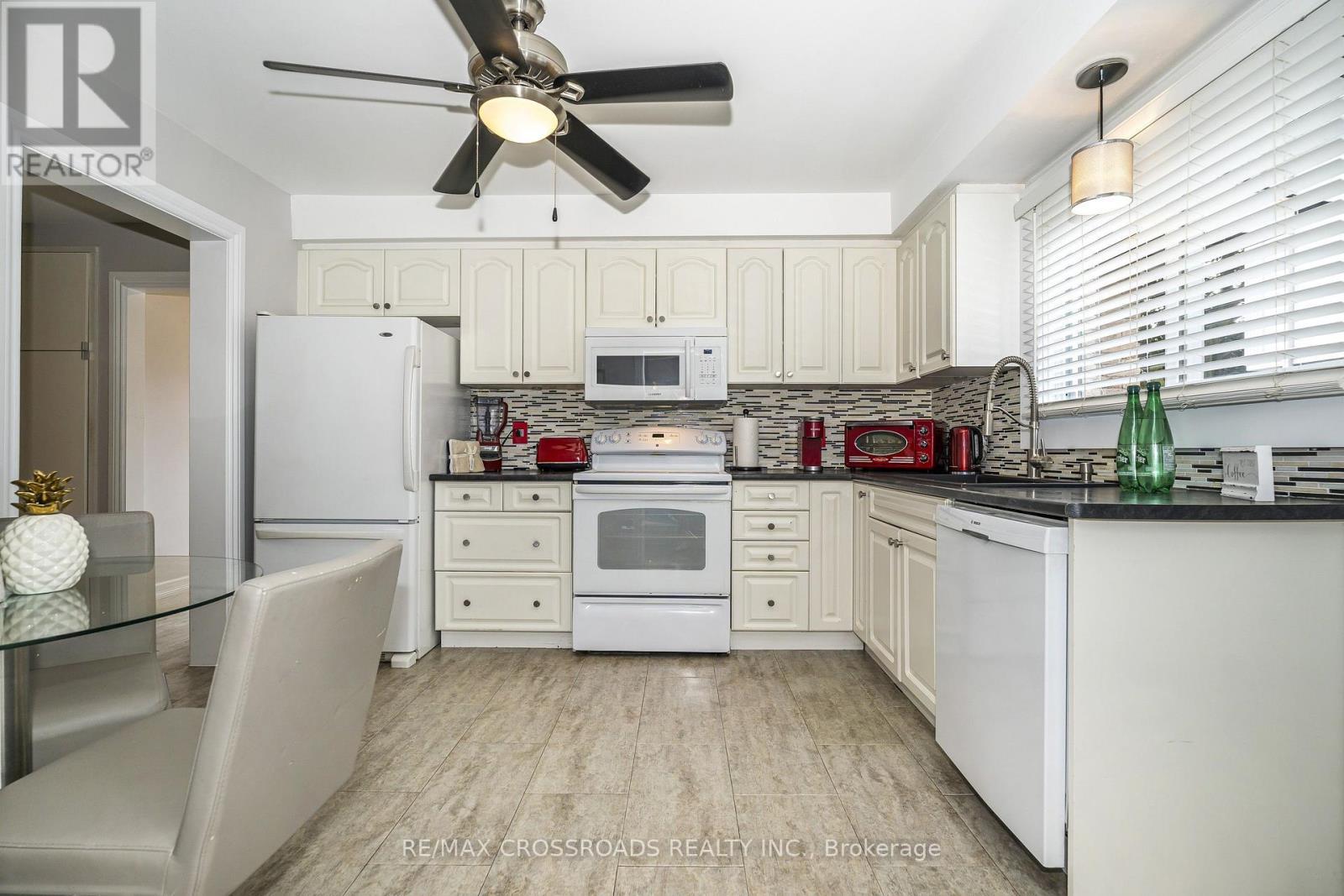 Modern Black CountertopsSink and Tile Backsplash - 655 Dodsworth Crescent, Mississauga, ON - Indoor Photo Showing Kitchen