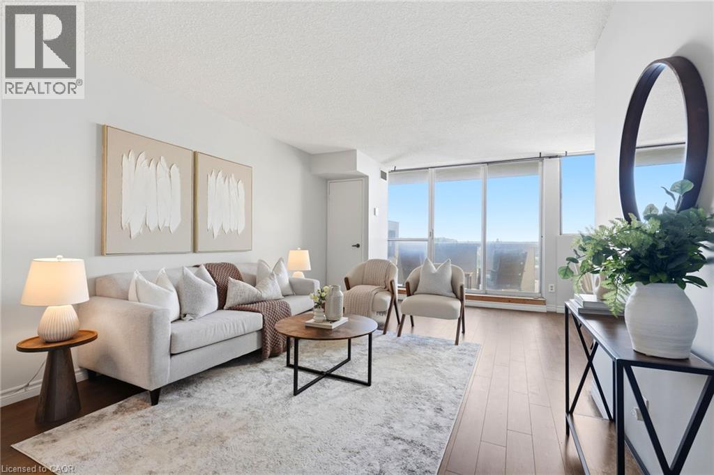 Expansive windows, wood-finish flooring, and white walls create a bright living space - 375 King Street N Unit# 708, Waterloo, ON - Indoor Photo Showing Living Room
