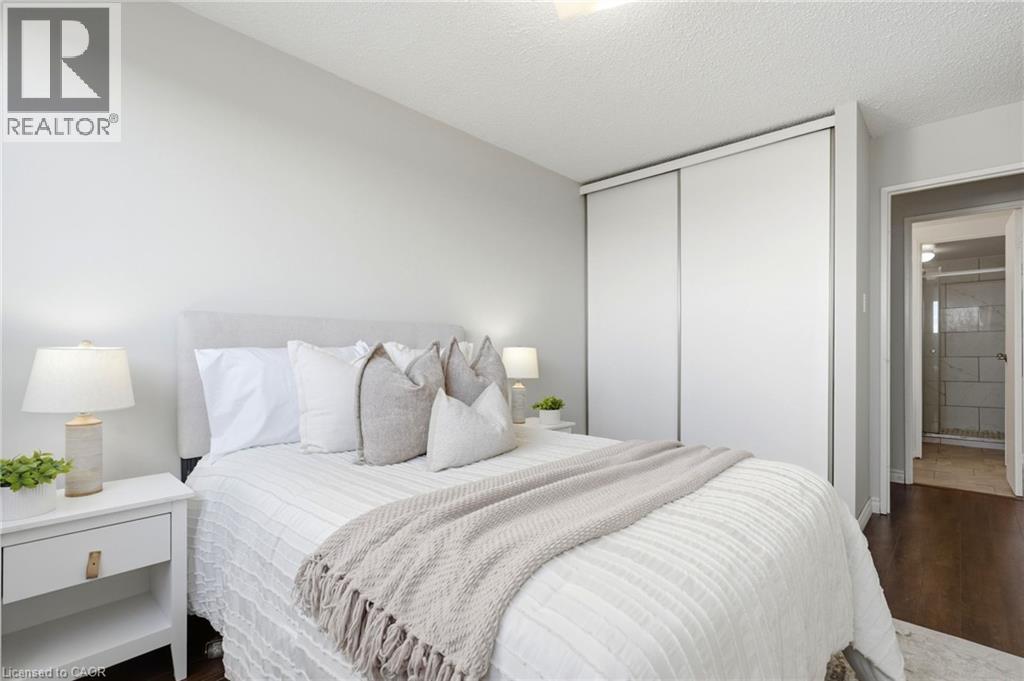 Wood-finish flooring, light grey wall paint, and white sliding closet doors - 375 King Street N Unit# 708, Waterloo, ON - Indoor Photo Showing Bedroom