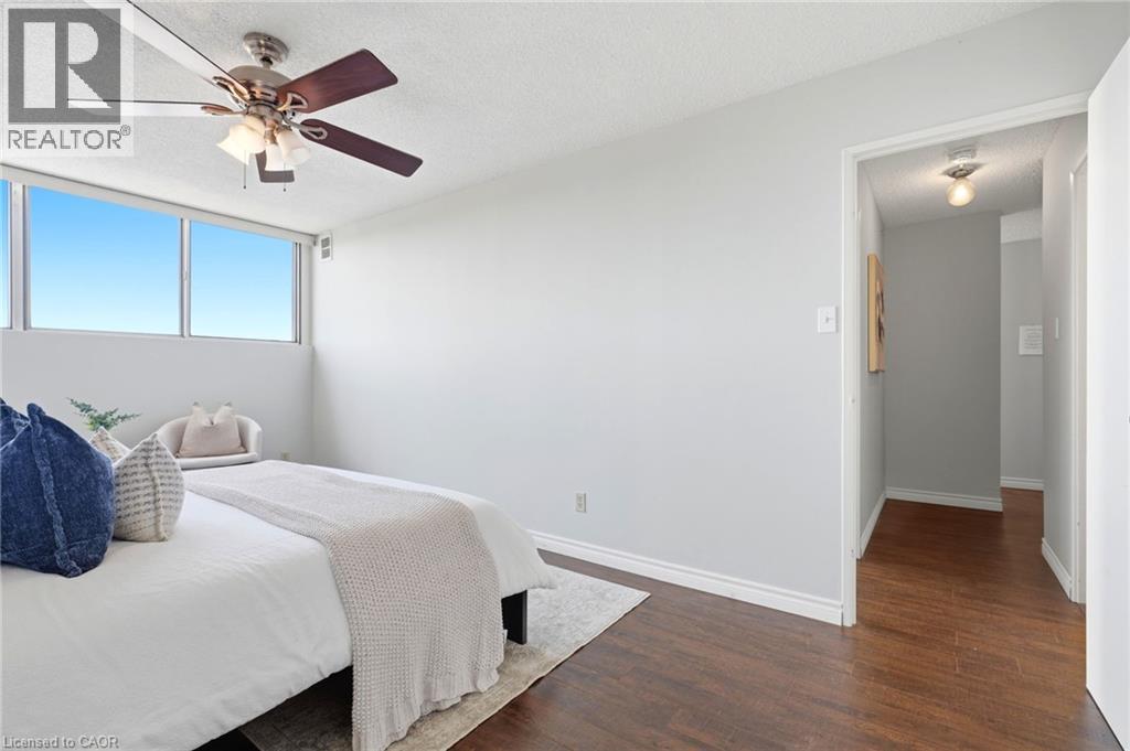 Expansive window offering abundant natural light, wood-finish flooring, and a ceiling fan with integrated lighting - 375 King Street N Unit# 708, Waterloo, ON - Indoor Photo Showing Bedroom