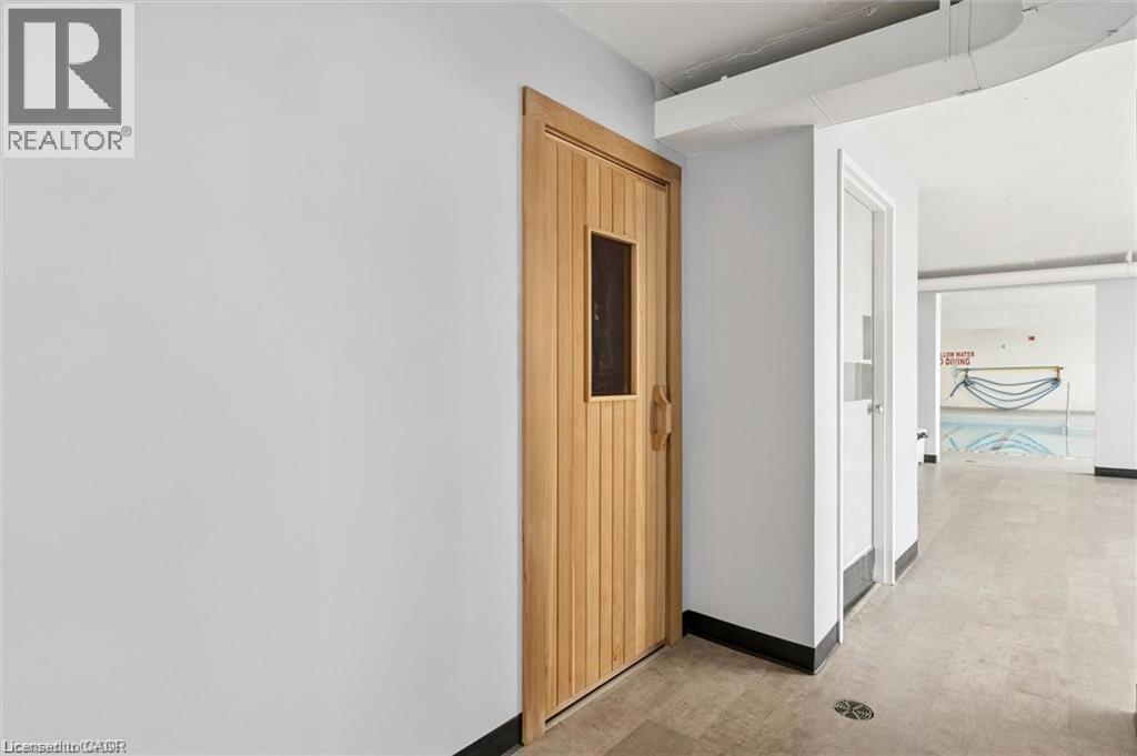 Wood-finish door with a small window, light-colored walls, and tile flooring - 375 King Street N Unit# 708, Waterloo, ON - Indoor Photo Showing Other Room