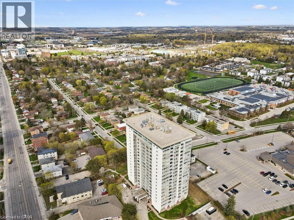 High-rise building with multiple balconies and a flat roof, surrounded by paved parking areas - 375 King Street N Unit# 708, Waterloo, ON - Outdoor With View