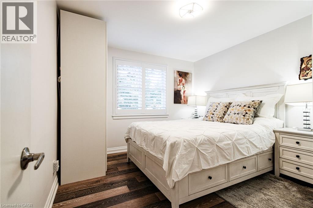 White walls with contrasting wood-finish flooring - 2105 Maplewood Drive, Burlington, ON - Indoor Photo Showing Bedroom